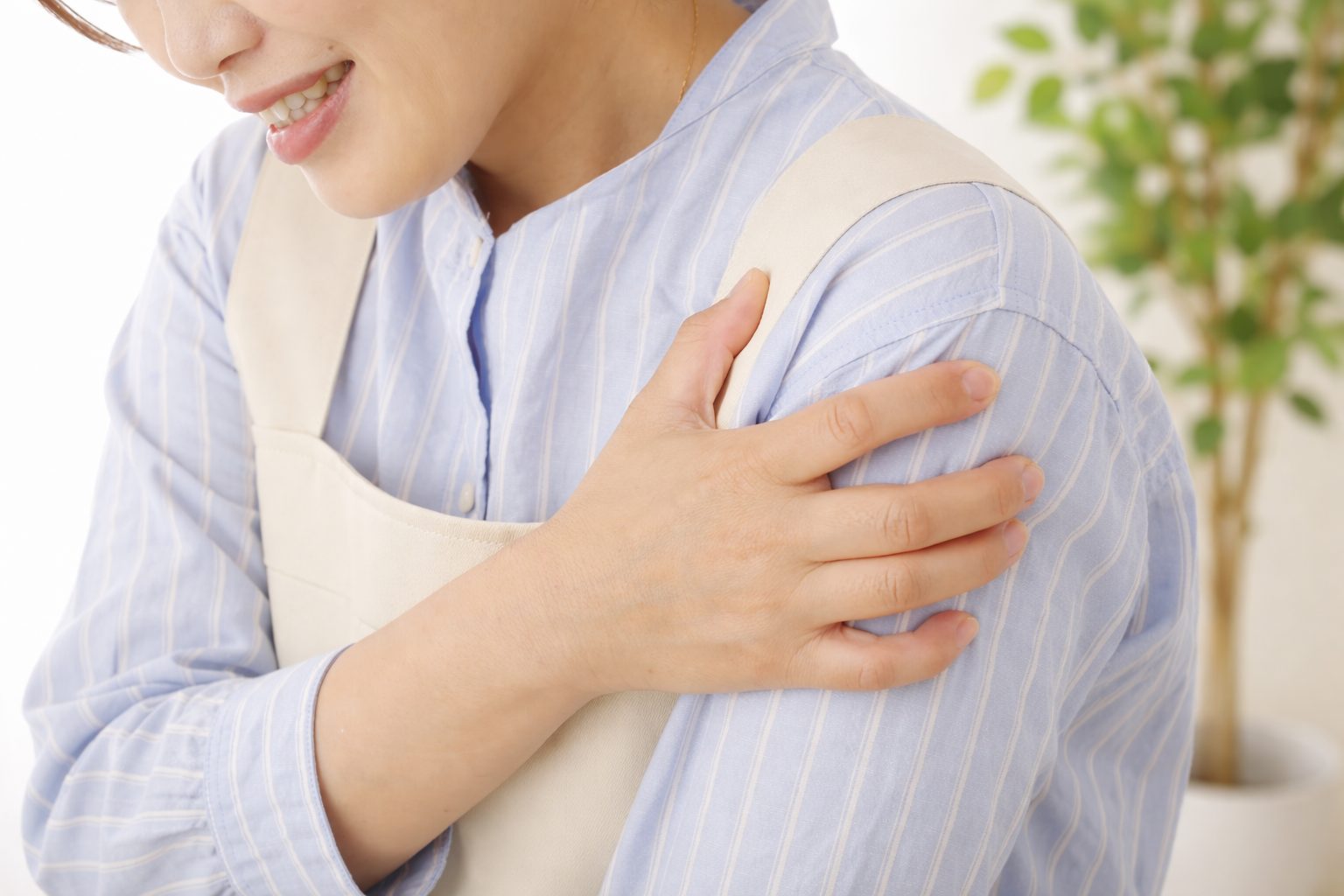 肩の痛みで日常動作がつらいイメージ